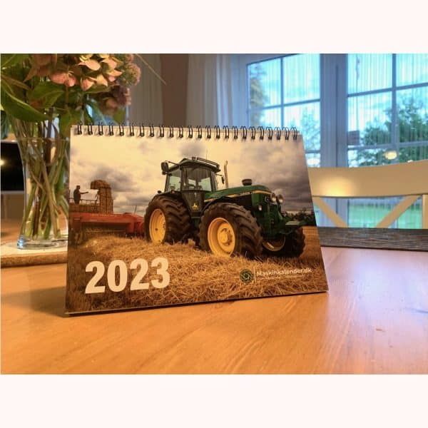 Traktorkalender med John Deere til 2023 på et bord